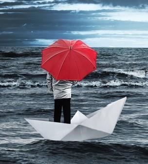 Coussins decoratifs homme avec un parapluie rouge sur un bateau de papier dans la mer orageuse jpg